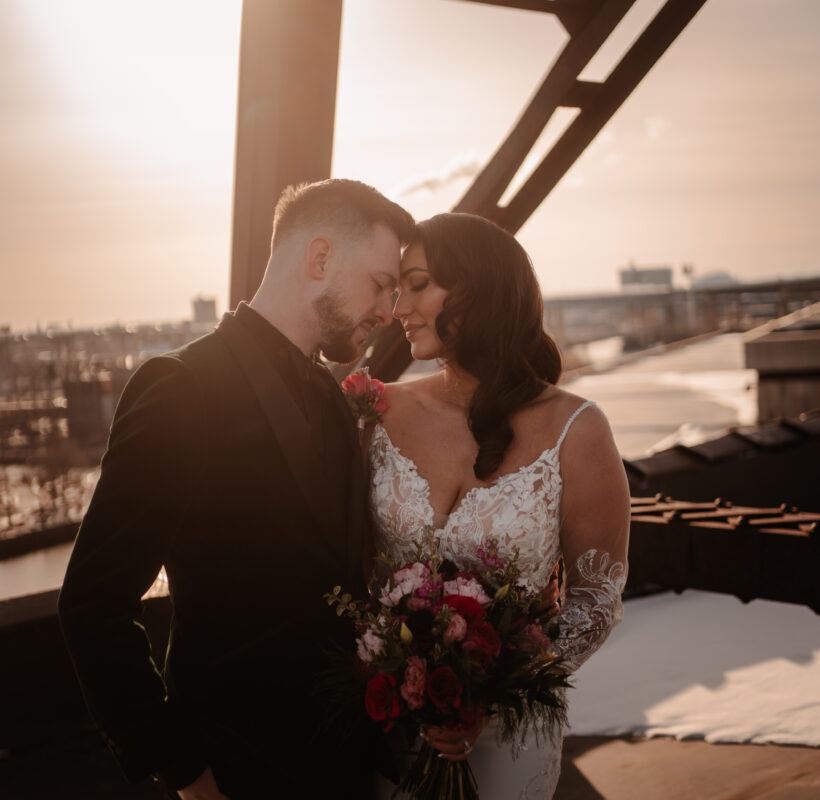 bride and groom touching foreheads at sunset on the rooftop