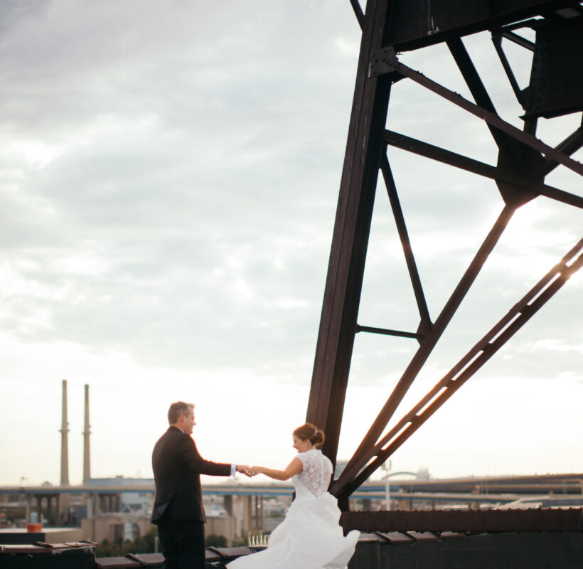 groom twirling bride on a rooftop