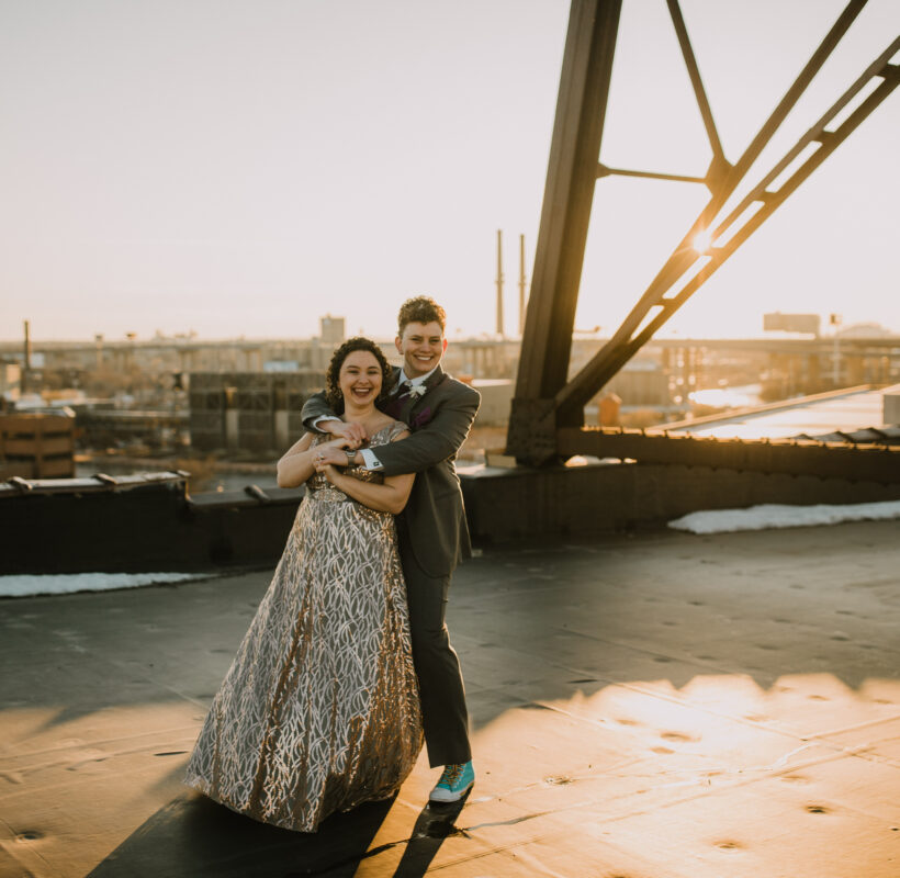 brides embracing each other while standing on the rooftop